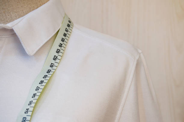 Hechura de camisas a la medida, una camisa blanca con una cinta métrica en el cuello