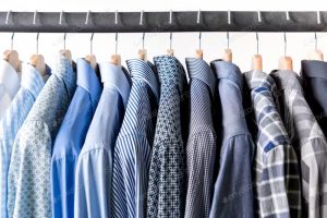 Camisas de vestir; línea de camisas azules colgadas en ganchos