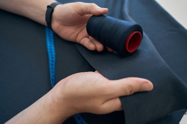 Telas para trajes; persona verificando que el color del hilo sea acorde