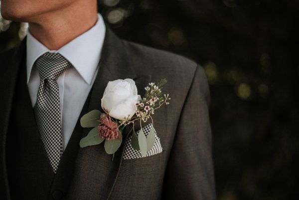 Trajes de novio; trajes gris Oxford con flor blanca